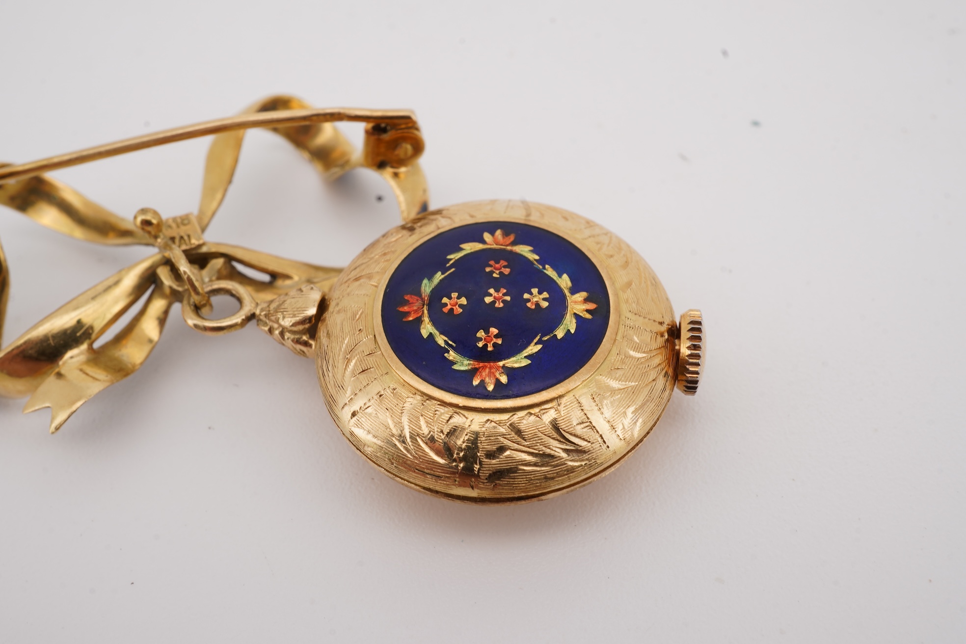 A mid 20th century Italian 18k and enamel fob watch, dial a.f., suspended from and Italian 18k and blue enamelled ribbon bow brooch, brooch width 30mm.